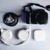 black Fujifilm DSLR camera and white corded headphones